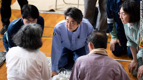 Japan&#39;s Prime Minister Shinzo Abe visits a shelter for people affected by the recent flooding in Mabi, Okayama prefecture on July 11, 2018.