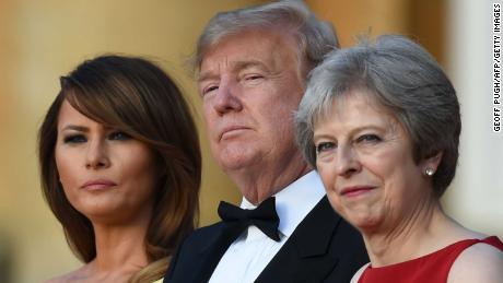 TOPSHOT - (L-R) US First Lady Melania Trump, US President Donald Trump and Britain&#39;s Prime Minister Theresa May stand on steps in the Great Court as the bands of the Scots, Irish and Welsh Guards perform a ceremonial welcome as they arrive for a black-tie dinner with business leaders at Blenheim Palace, west of London, on July 12, 2018, on the first day of President Trump&#39;s visit to the UK. - The four-day trip, which will include talks with Prime Minister Theresa May, tea with Queen Elizabeth II and a private weekend in Scotland, is set to be greeted by a leftist-organised mass protest in London on Friday. (Photo by Geoff PUGH / POOL / AFP)        (Photo credit should read GEOFF PUGH/AFP/Getty Images)