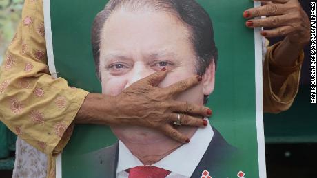 A supporter of ousted former Pakistani prime minister Nawaz Sharif holds his picture ahead of a rally led by his younger brother. 