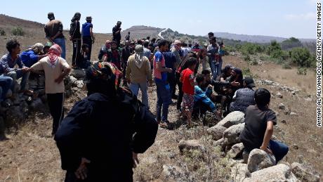 Syrians approach the frontier fence in the Golan Heights on Tuesday.