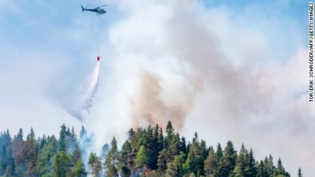 Firefighters use helicopters to fight wildfires in the southern part of Norway in Sordal on July 14.