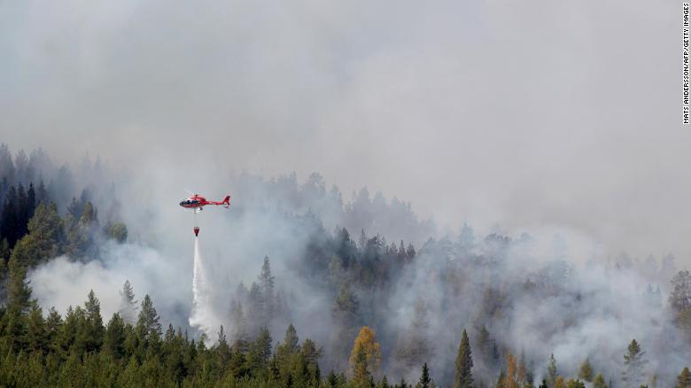 Firefighters use helicopters to fight wildfires outside Hammarstrand in Sweden on July 16.