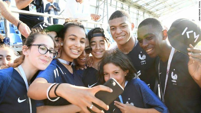 Kylian Mbappe poses for a photo with the pupils from school Jean Renoir.