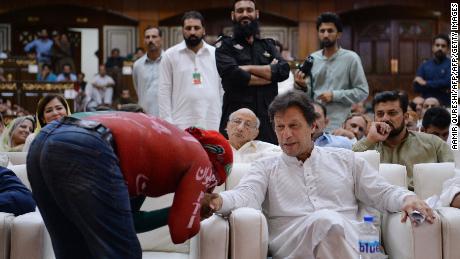 A supporter kisses the hand of cricketer-turned-politician and head of the Pakistan Tehreek-i-Insaf (PTI) Imran Khan as he attends an election campaign rally in Islamabad on June 30, 2018.