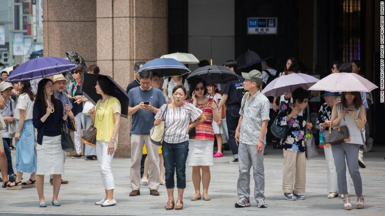 People use parasols to try and escape the heat on July 22, 2018 in Ginza Tokyo, Japan.