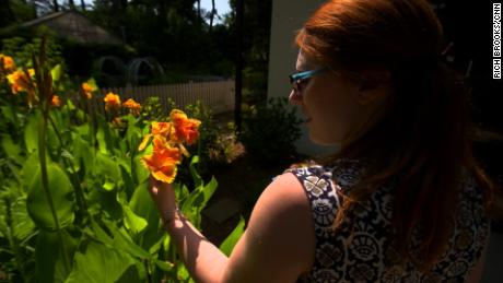 A horticultural therapy client pauses to admire a flower. 