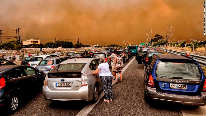 Cars are blocked at the closed National Road during a wildfire in Kineta, near Athens.