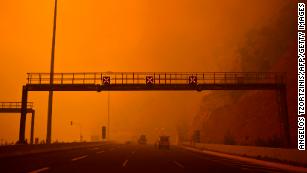 Greeks skies are reddened above a road block on the road to Kineta, near Athens. 