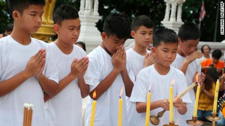Chanin Vibulrungruang lights a candle with members of the rescued soccer team during a Buddhist ceremony on July 24.