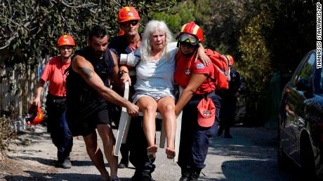 Members of a rescue team carry an injured woman Wednesday in Mati.