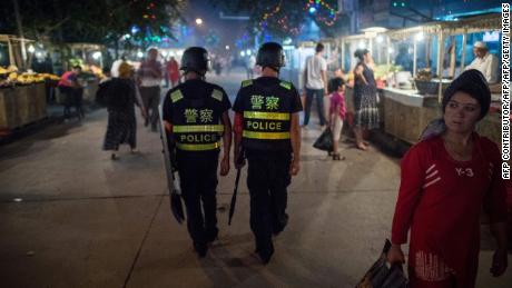 Police patrol in a night food market near the Id Kah Mosque in Kashgar in China&#39;s Xinjiang Uighur Autonomous Region.