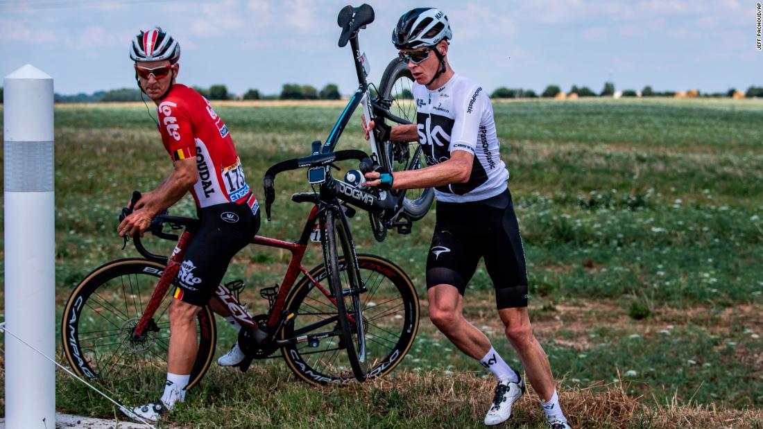 Belgium&#39;s Jasper De Buyst, left, and Britain&#39;s Chris Froome get back on the road after crashing during the first stage on July 7. Froome is the defending champion.