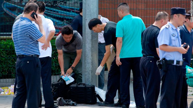 Chinese officials work near the site of a reported blast just south of the US Embassy in Beijing, on July 26.