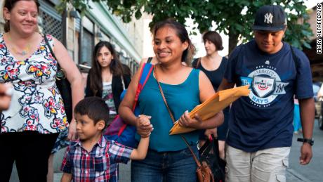 Julie Schwietert-Collazo, left, of Immigrant Families Together, walks with Rosayra Pablo Cruz, center, as she leaves the Cayuga Center with her sons 5-year-old Fernando, second from left, and 15-year-old Jordy on July 13 in New York.