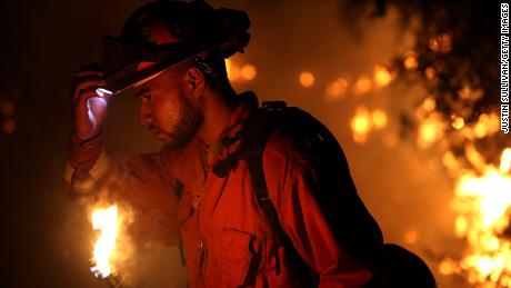 A firefighter monitors a backfire while battling the larger Carr Fire on Friday in Redding.