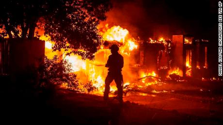 A firefighter battles the fast-moving Carr Fire on Thursday at a house in Redding, California.