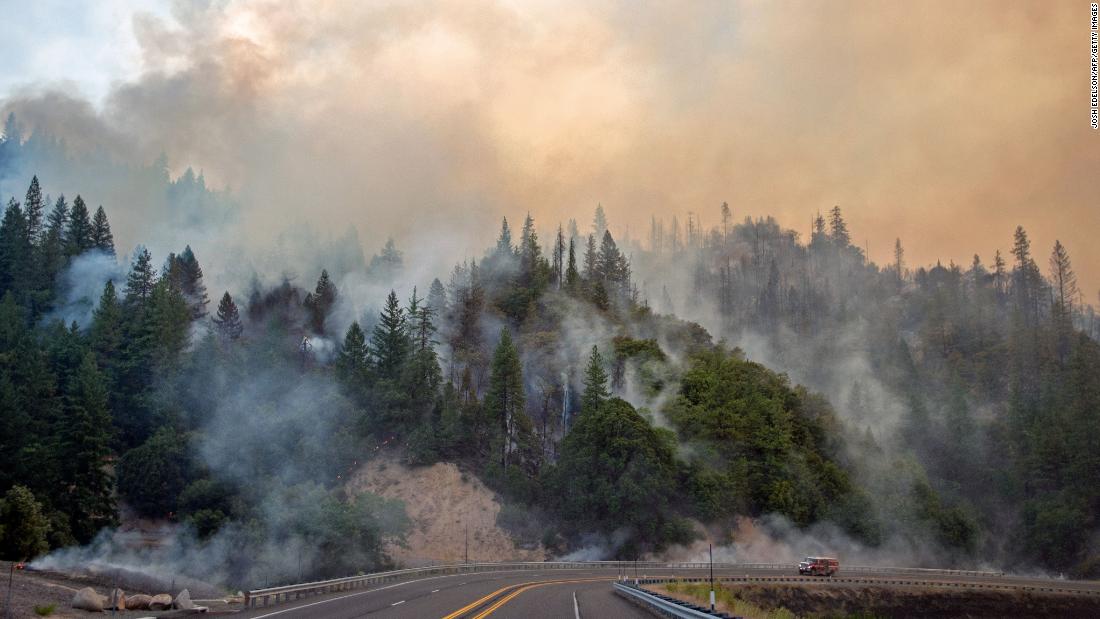 A fire truck drives along Highway 299 as the Carr fire continues to burn near Whiskeytown on July 28.