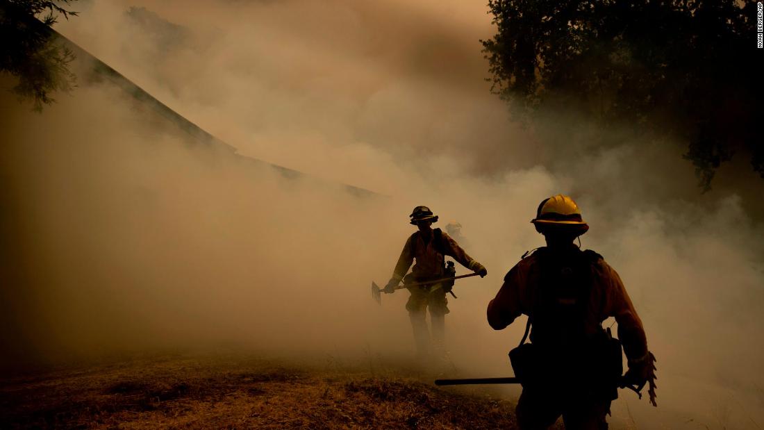 A firefighter walks through smoke while fighting to save a winery in Lakeport on July 30.