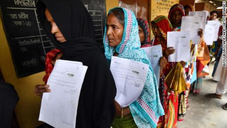 Residents hold their documents as they stand in a queue to check their names on the final list of National Register of Citizens.