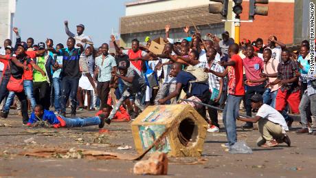 Opposition supporters react after police fire tear gas in Harare on Wednesday.