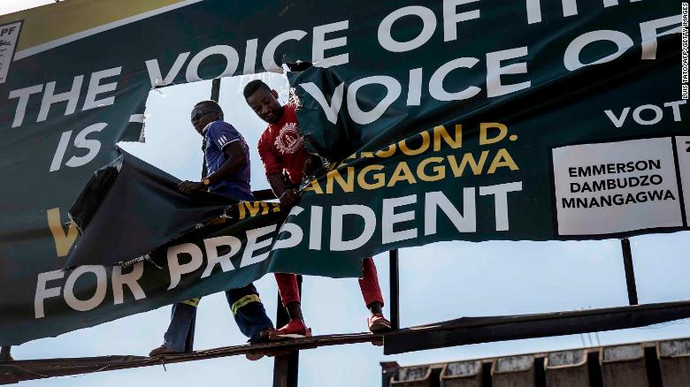 Supporters of Zimbabwean opposition MDC Alliance Party rip up an electoral poster in support of ZANU-PF party in Harare.