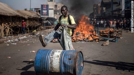 A supporter of the opposition pushes a barrel in front of a fire during a protest this week in Harare. 