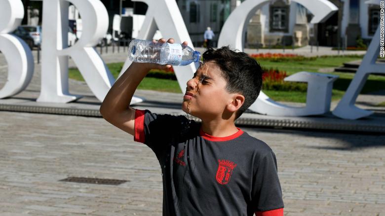 A child pours water over himself in Braga, northern Portugal, on Wednesday.