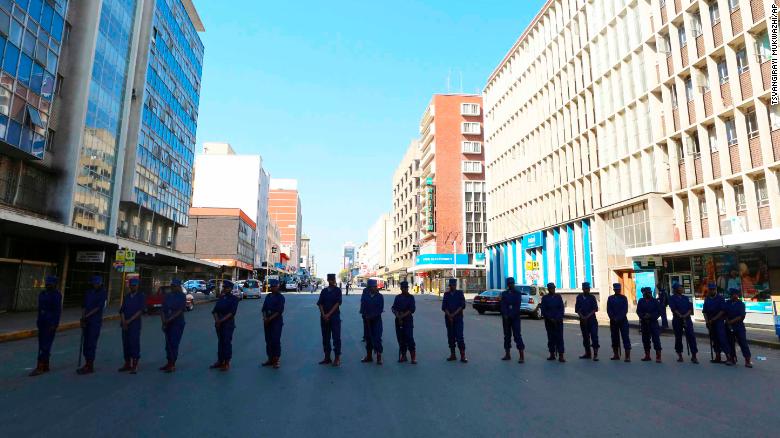 Zimbabwe police officers block the road leading to the opposition offices in the capital Harare on Thursday.