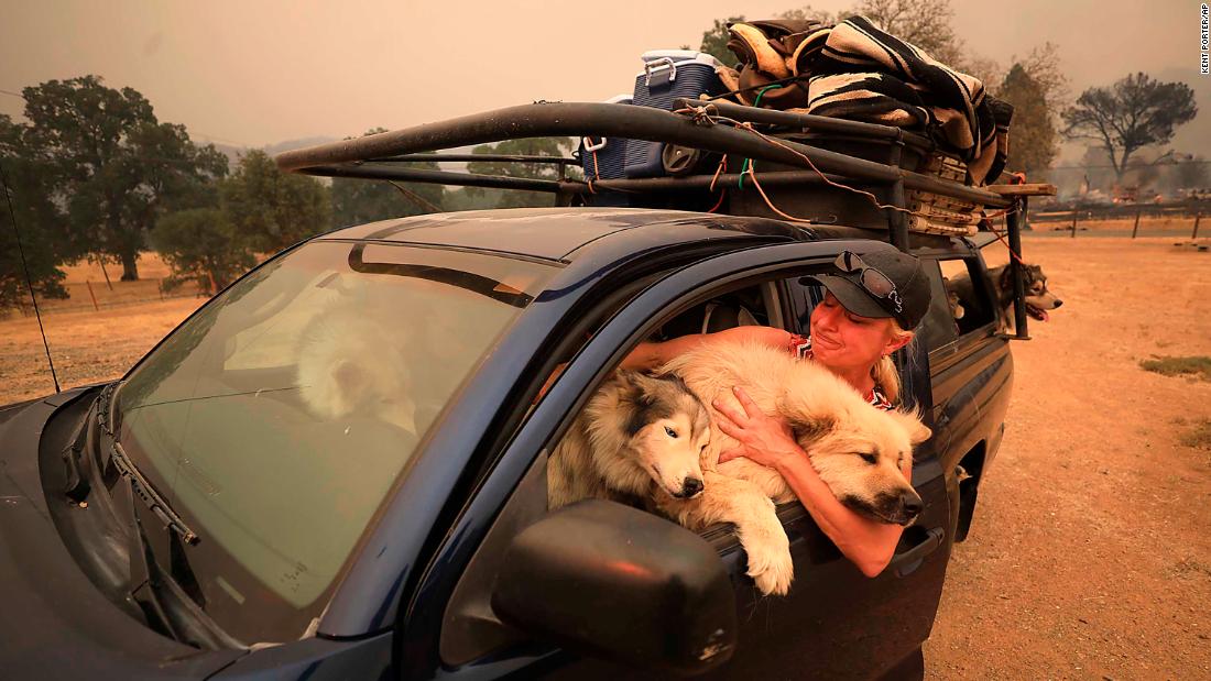 Crystal Easter comforts her dogs as they flee a wildfire in Spring Valley on Monday, August 6.