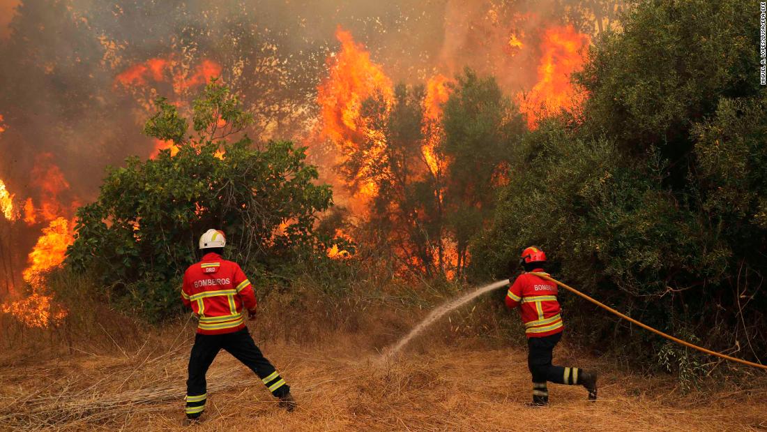 Firefighters try to extinguish a wildfire in Monchique, Portugal, on Tuesday, August 7.