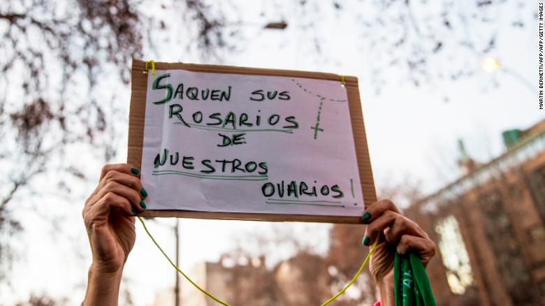 An activist in favour of the legalization of abortion holds a sign reading &quot;Take out your Rosaries from our ovaries&quot; during a demonstration outside of Argentina&#39;s embassy in Santiago de Chile.