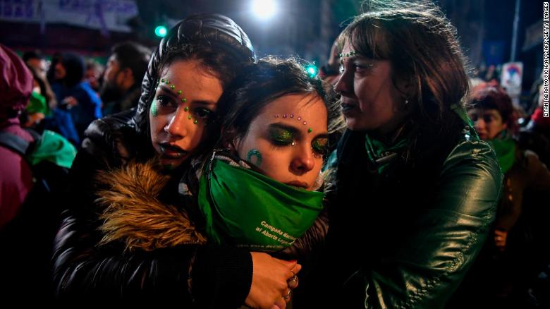 Activists in favour of the legalization of abortion comfort each other outside the National Congress in Buenos Aires.