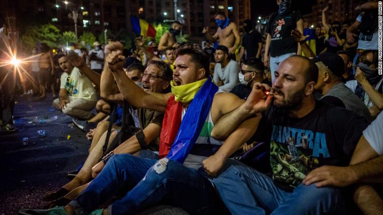 Romanians take part in a demonstration in front of the government headquarters in Bucharest on Friday.