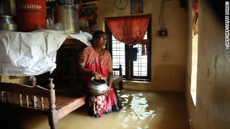 TOPSHOT - An Indian woman sits inside her houses immersed in flood waters in Ernakulam district of Kochi, in the Indian state of Kerala on August 10, 2018. - Flash floods have claimed at least 27 lives in the southern Indian state of Kerala, officials said on August 10, prompting the US to advise its citizens to stay away from the tourist hotspot. (Photo by - / AFP)        (Photo credit should read -/AFP/Getty Images)