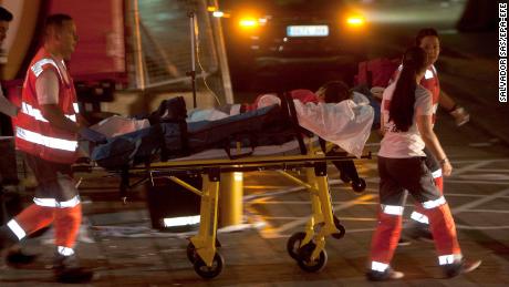 Red Cross paramedics transport an injured person to the hospital after the platform collapsed late Sunday night.