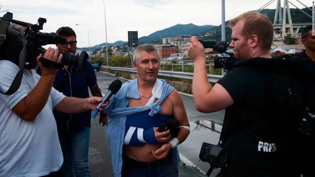 An injured man speaks to reporters near the bridge.