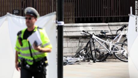 Police officers stand guard near bicycles believed to have been damaged in the crash