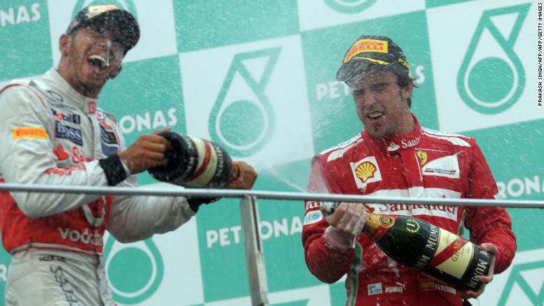 Ferrari driver Fernando Alonso of Spain (R) and McLaren-Mercedes driver Lewis Hamilton (L) of Britain celebrate on the podium with champagne after Formula One&#39;s Malaysian Grand Prix in 2012.