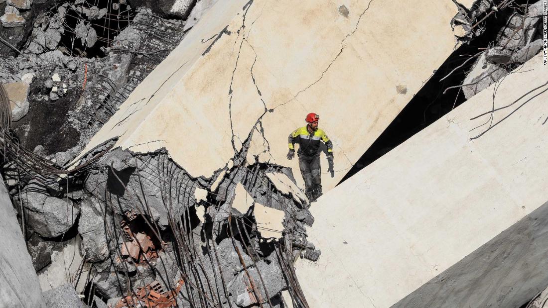 A rescuer climbs through the rubble of the bridge in search of victims and survivors.