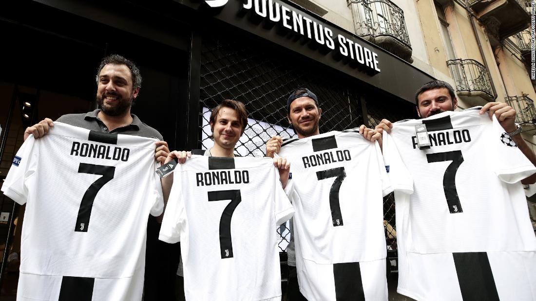 Juve supporters show off their Cristiano Ronaldo jerseys in front of the club&#39;s shop in Turin after the Serie A team signed the Portuguese star.