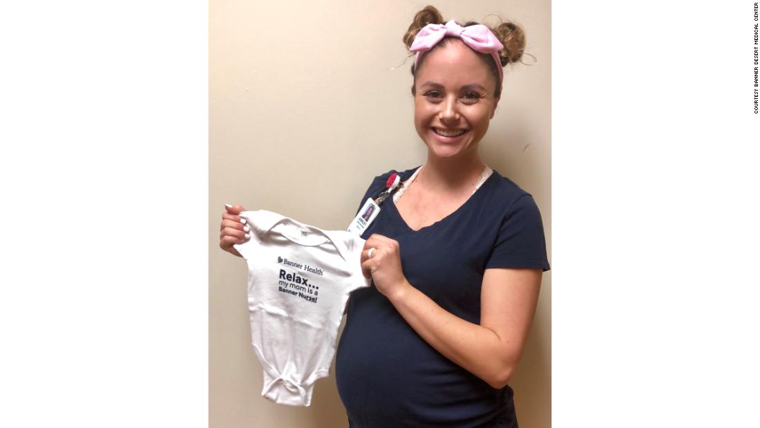 One of the pregnant nurses at Banner Desert Medical Center holds a onesie given to her by the hospital.