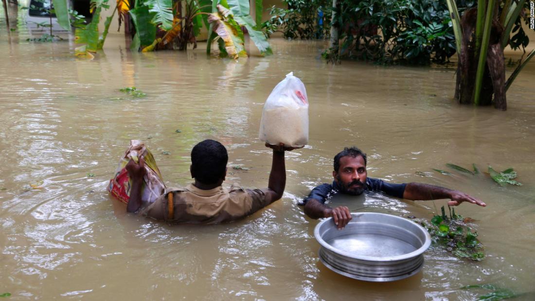 Rescue teams wade through filthy waters to help flood victims