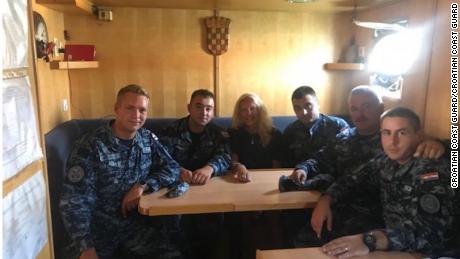 The woman sits with members of the Croatian Coast Guard.