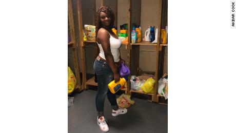 Student Rah-Asia Marrow stocks the shelves with donated laundry detergent for the student laundromat at West Side High School.