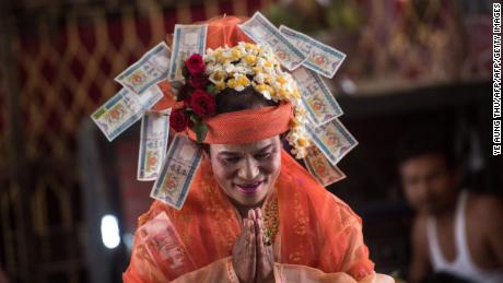 Mediums spin around in a frenzy of red and gold while glugging from a bottle of whiskey, part of an age old ritual to honour Myanmar's spirit guardian of drunkards and gamblers. 