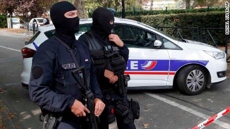 French hooded police officers cordon off the area after a knife attack Thursday, Aug. 23, 2018 in Trappes, west of Paris. A man flagged by French authorities as a suspected radical killed his mother and sister and seriously injured another woman in a knife attack Thursday that was quickly claimed by the Islamic State group. (AP Photo/Michel Euler)