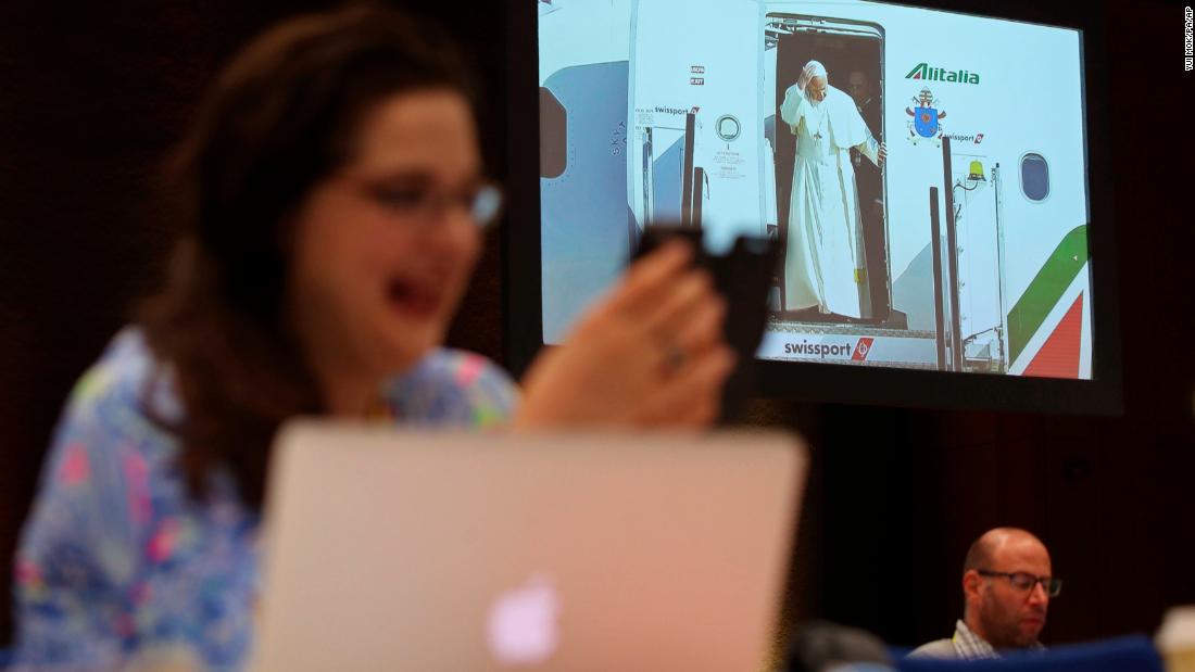 A journalist reacts inside the media center as Pope Francis arrives at Dublin Airport on Saturday.
