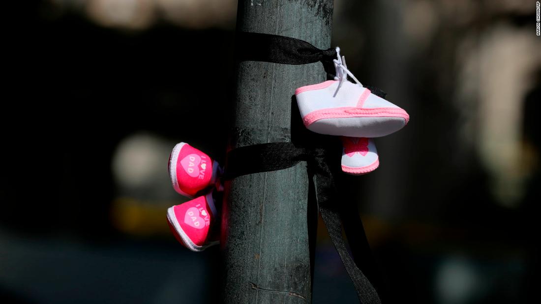 Protesters tie baby shoes to a post, signifying the children who died in mother and baby homes in Ireland, during a protest in Dublin ahead of the start of the Pope&#39;s visit to Ireland.