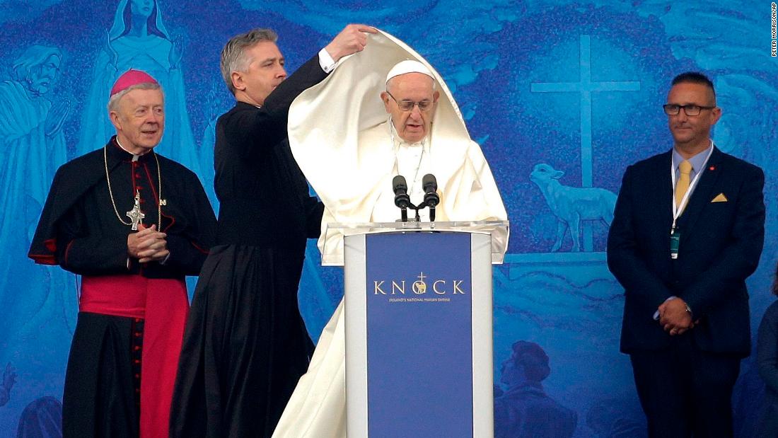 An aide adjusts Pope Francis&#39; cape as he speaks at the Knock Shrine in Knock, Ireland, on Sunday.