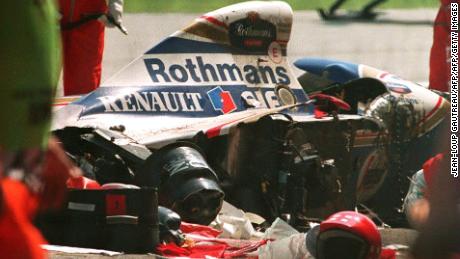 Security personnel surround the crashed car of Brazilian Formula One driver Ayrton Senna.